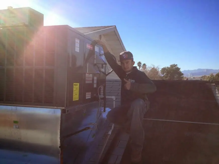 HVAC technician performing Heat Pump Repair on a rooftop unit in Woodbridge